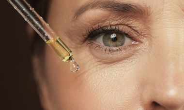 Female eye and dropper with rejuvenating serum